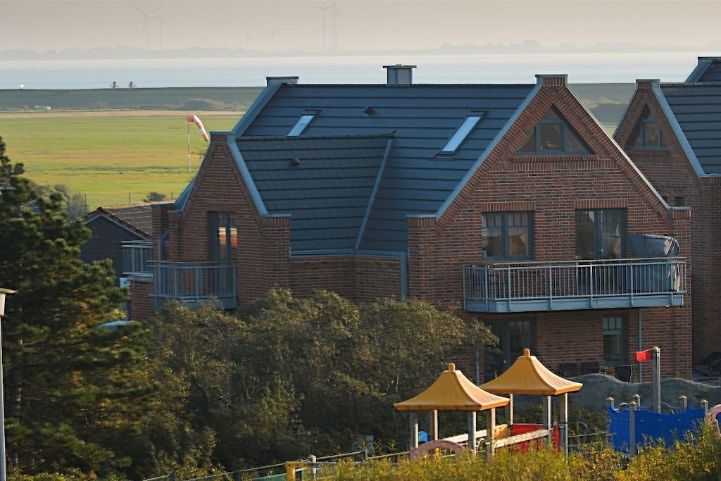 A residential building with a brick facade, multiple chimneys, and a balcony.