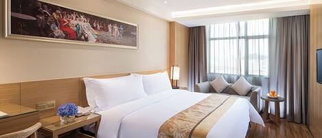 A hotel room with a large bed, a desk, a chair, a TV, and a painting on the wall.