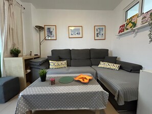 A modern living room with a grey sofa, a coffee table with a polka dot tablecloth, and framed pictures on the wall. - New Listing (Benalmádena)
