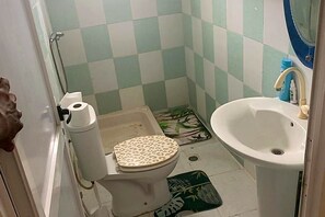 Ein Badezimmer mit Toilette, Waschbecken und Dusche.