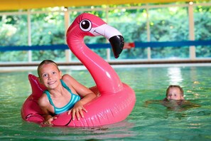 En person i en swimmingpool på en lyserød flamingo-svømmelegetøj.