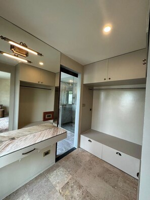 Een moderne badkamer met een grote spiegel, een douche en een wastafel met een marmeren blad.