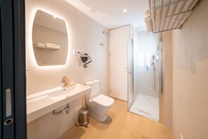 A modern bathroom with a glass shower enclosure, a white sink, and a toilet. - New Listing (El Prat de Llobregat)