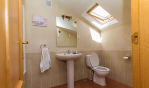 A bathroom with a skylight, a sink, a toilet, and a towel rack. - Country House 'El Salón Del Baile' with Mountain View and Balcony (Navarredondilla)