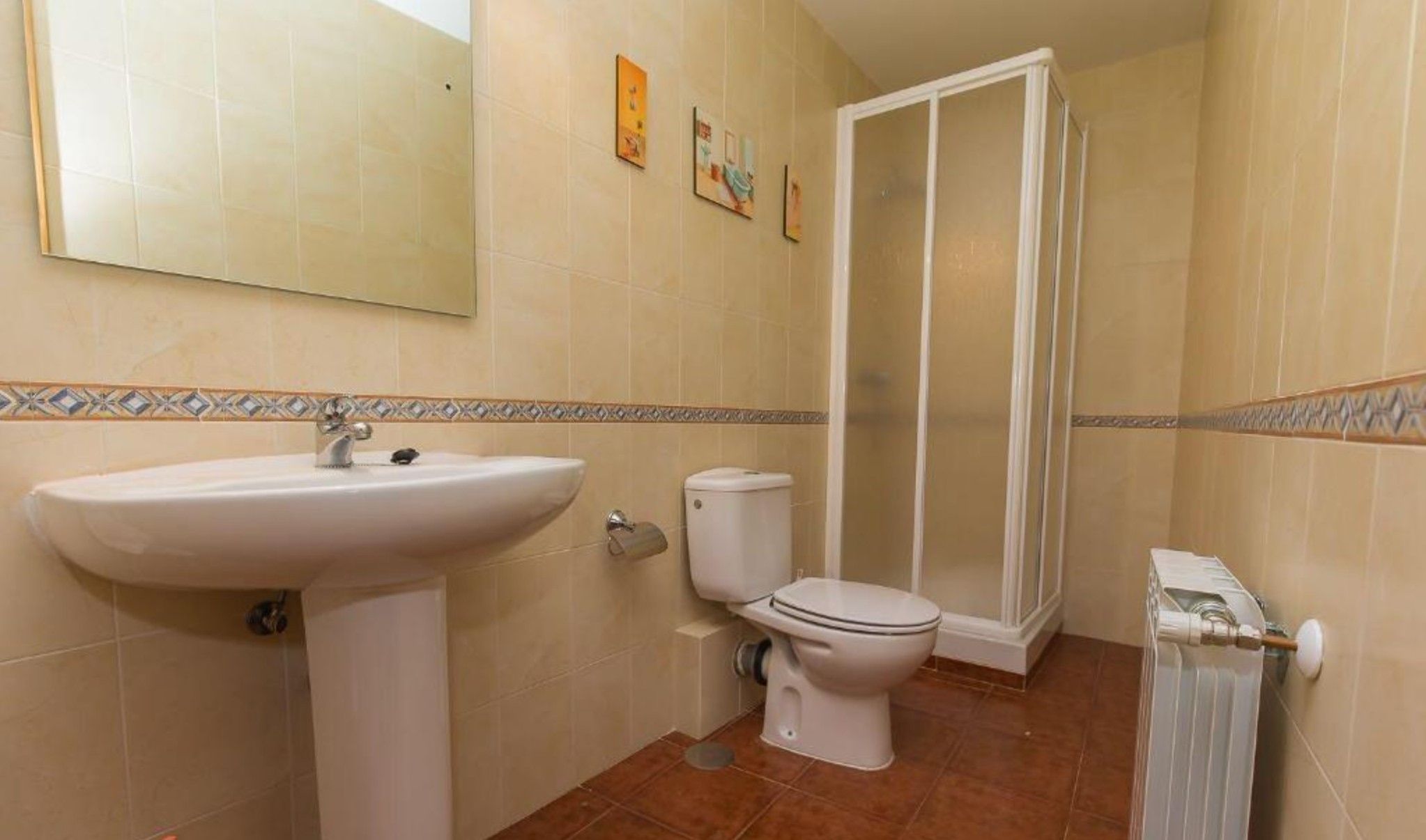 Une salle de bain équipée d’un lavabo, de toilettes et d’une douche.
