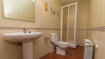 Une salle de bain équipée d’un lavabo, de toilettes et d’une douche.