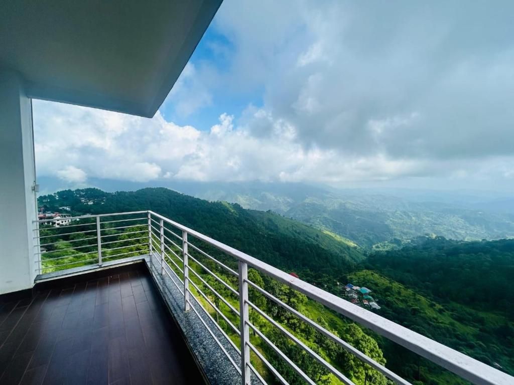 Un balcon doté d’une rambarde en métal, d’où l’on peut admirer un paysage montagneux.