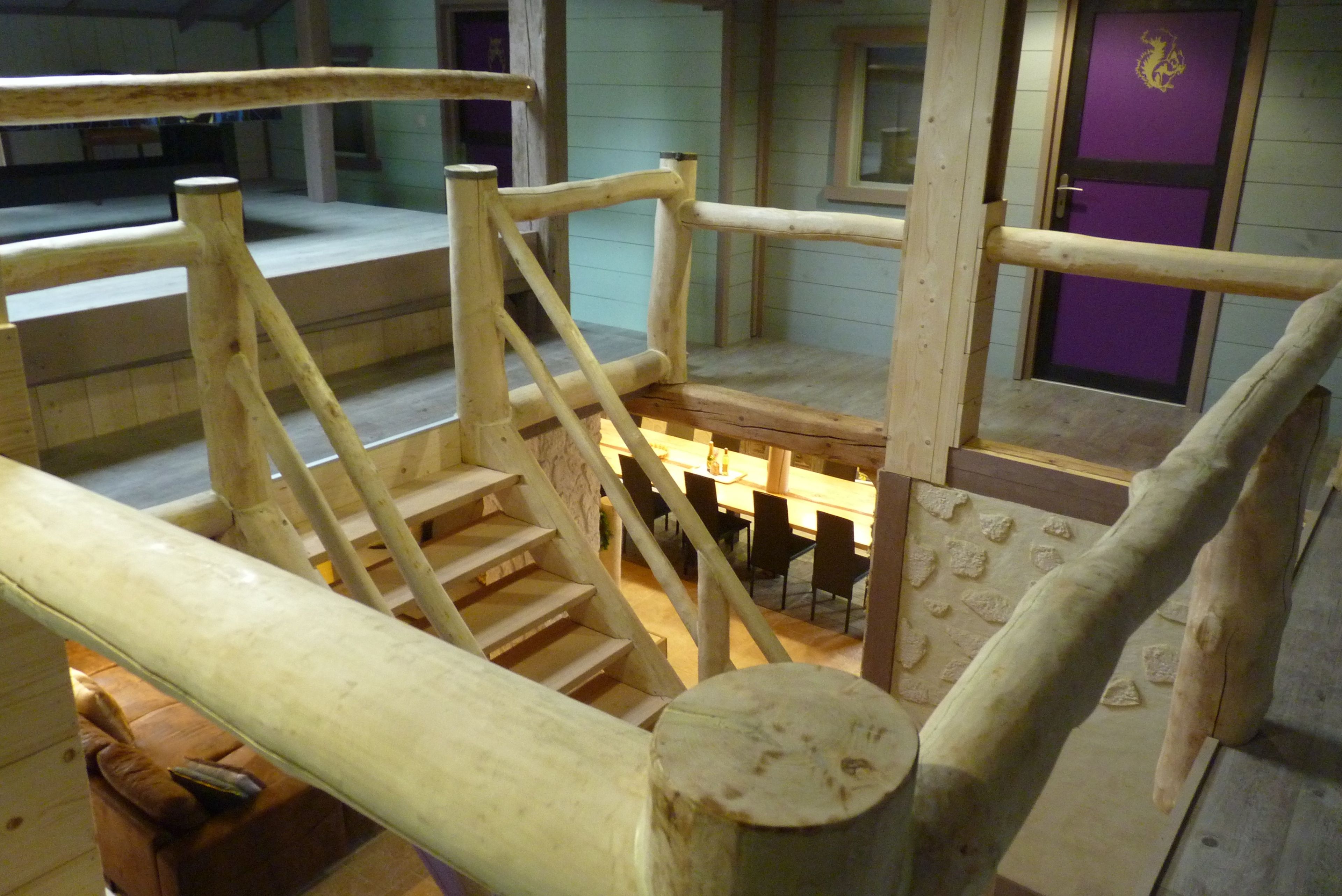Una escalera de madera con barandilla que lleva a una plataforma.