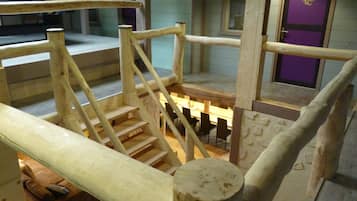 Una escalera de madera con barandilla que lleva a una plataforma.