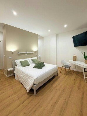 A modern bedroom with a bed, bedside tables, a desk, a chair, and a television. - Terrace with sauna and hot tub in Villamagna (Villamagna)