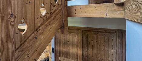 Un escalier en bois orné de découpes en forme de cœur et doté d’une rampe en bois.