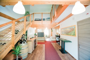 Un intérieur spacieux avec un escalier en bois, un coin repas et une cuisine.