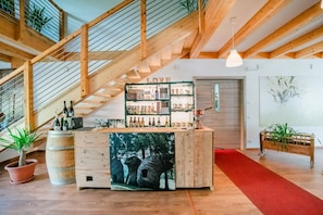 A wooden interior with a staircase, a bar area with bottles, and a red carpet. - Room 2 in Borgo Valsugana – double or triple, self check-in (Borgo Valsugana)