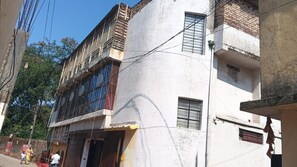 Un edificio de varios pisos con un balcón en el segundo nivel y una entrada a pie de calle.
