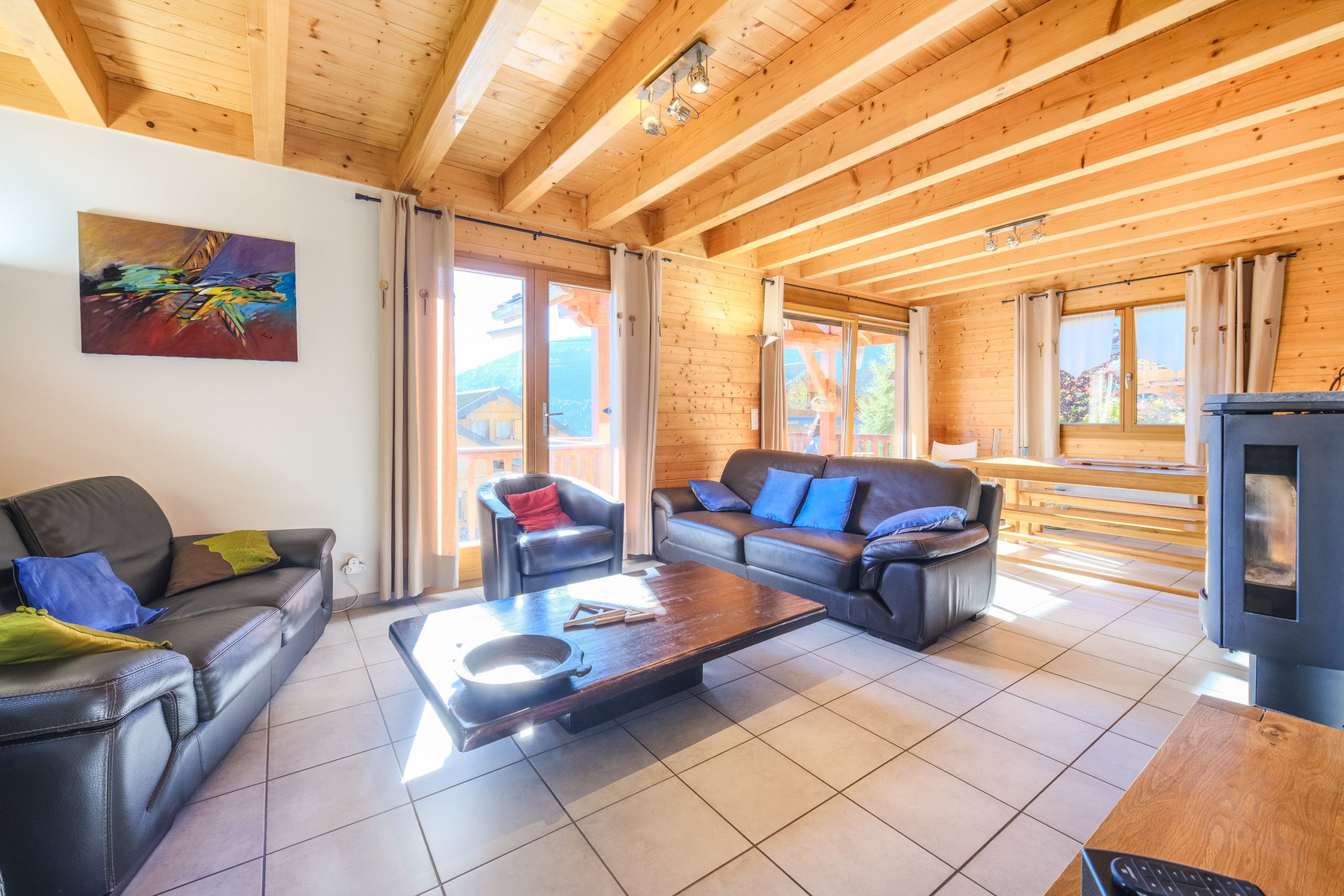 A wooden interior with a sofa, armchairs, and a coffee table.