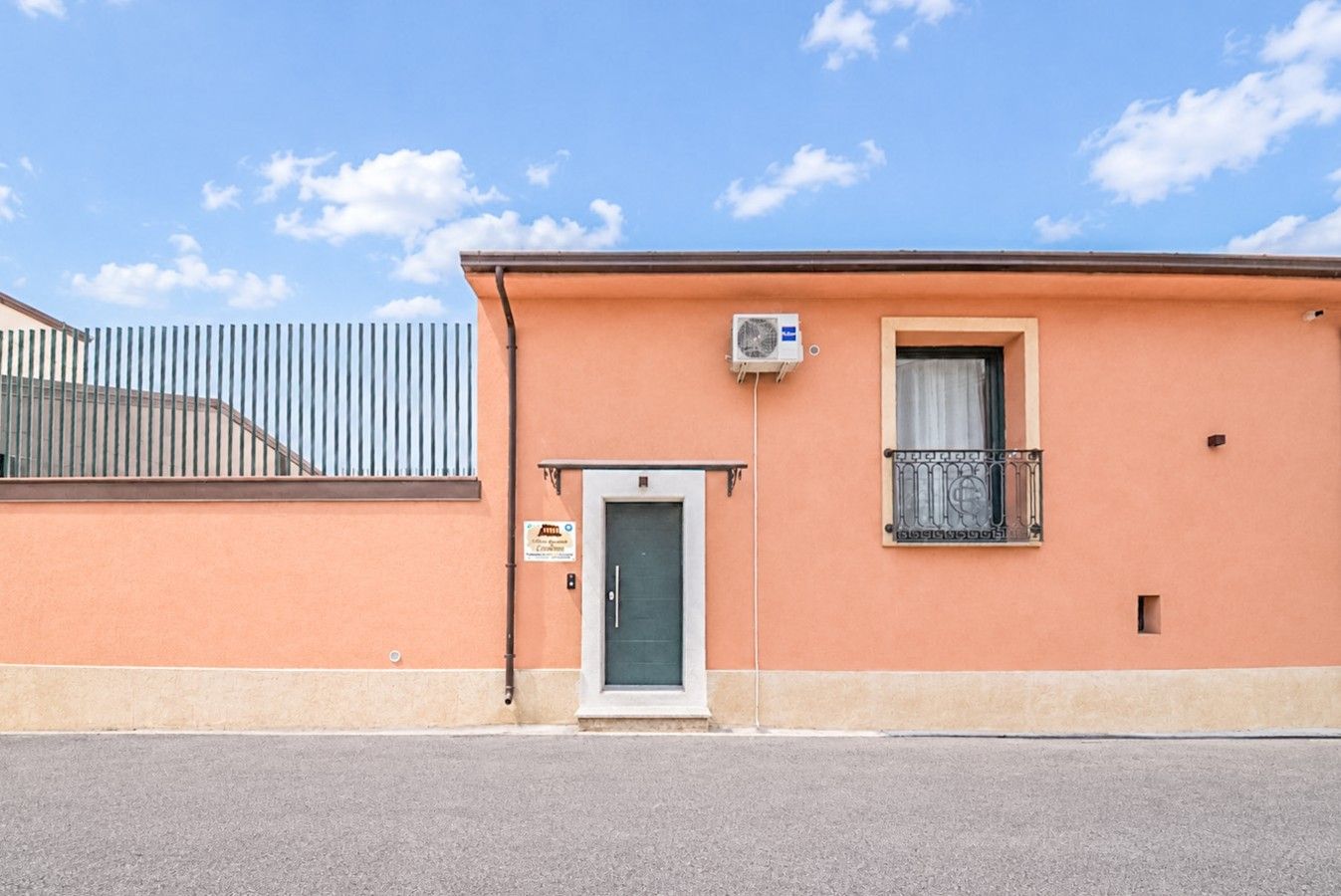 A building with a single door and a small window with a balcony.