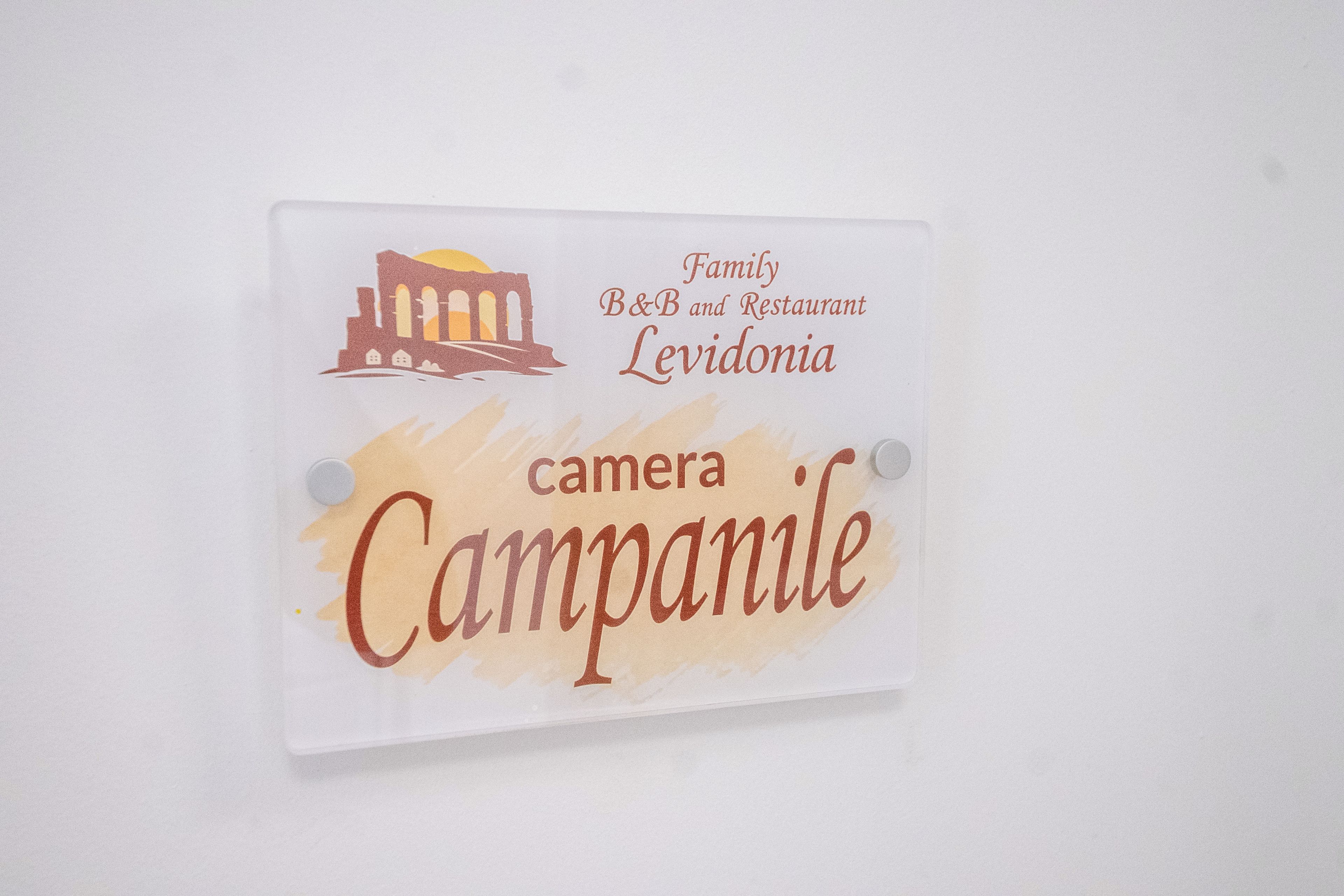 A sign with the text 'Family B&B and Restaurant Levidonia' and 'camera Campanile'.