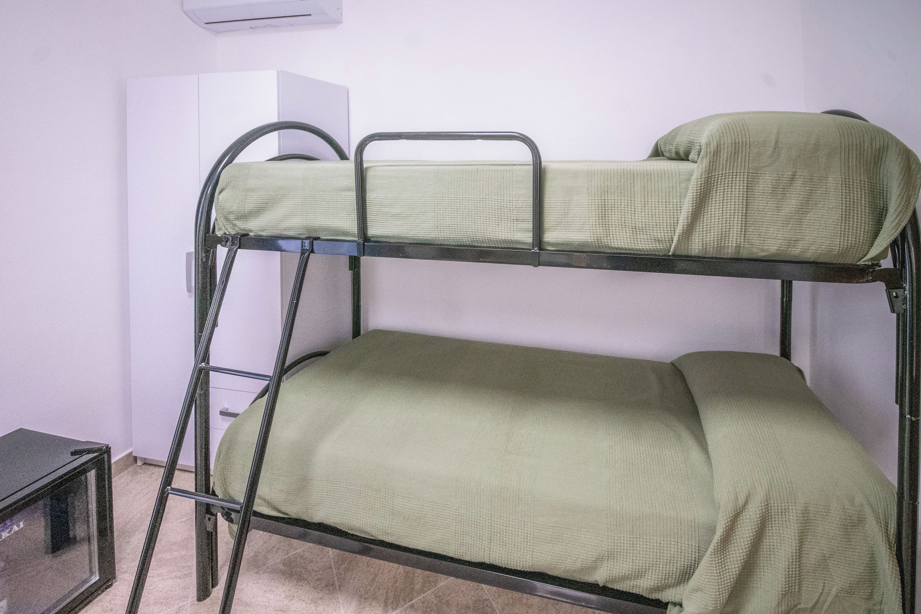 Una cama litera con colchón y estructura metálica.