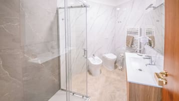 Ein modernes Badezimmer mit Duschkabine aus Glas, einem weißen Waschbecken und einer Toilette.