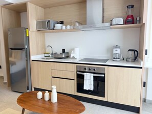 Ett modernt kök med inbyggd mikrovågsugn, ugn och kaffebryggare.