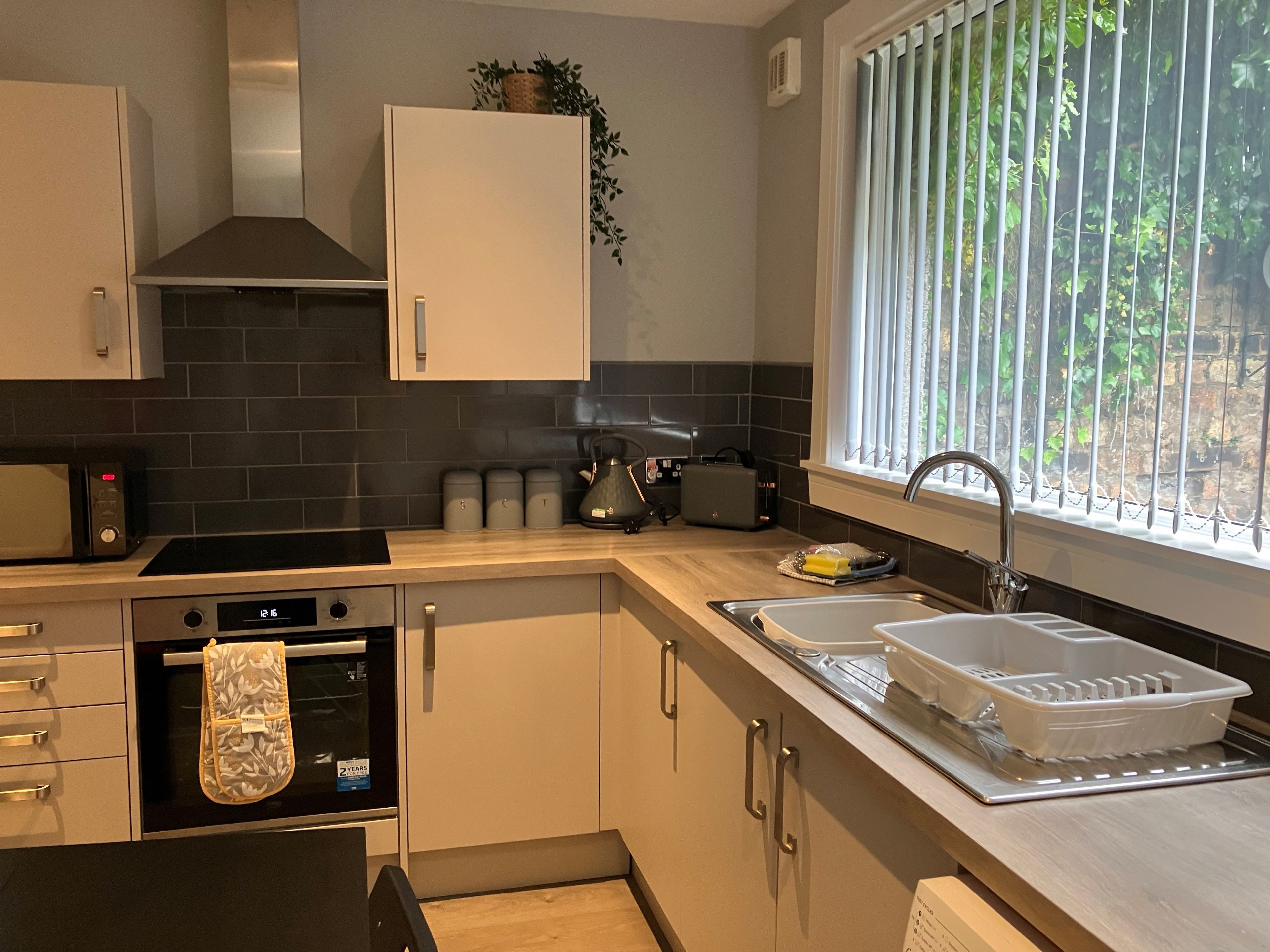 A modern kitchen with a microwave, oven, and sink.