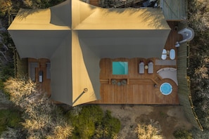 Um espaço de estar ao ar livre moderno, com vários níveis, piscina, áreas de estar e um deck de madeira.