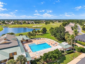 Ein Resort mit Schwimmbad, Liegestühlen und Blick auf einen Golfplatz und einen See.
