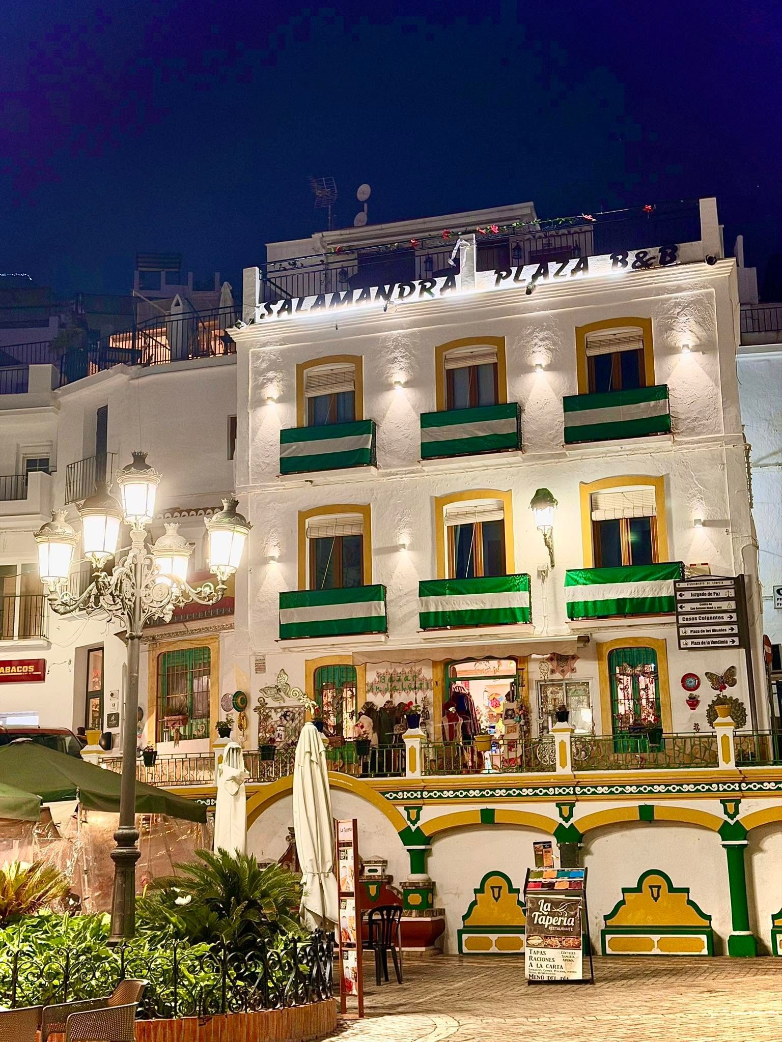 Un bâtiment sur lequel on peut lire, sur une enseigne, les mots « SALAMANDRA PLAZA B&B » la nuit.