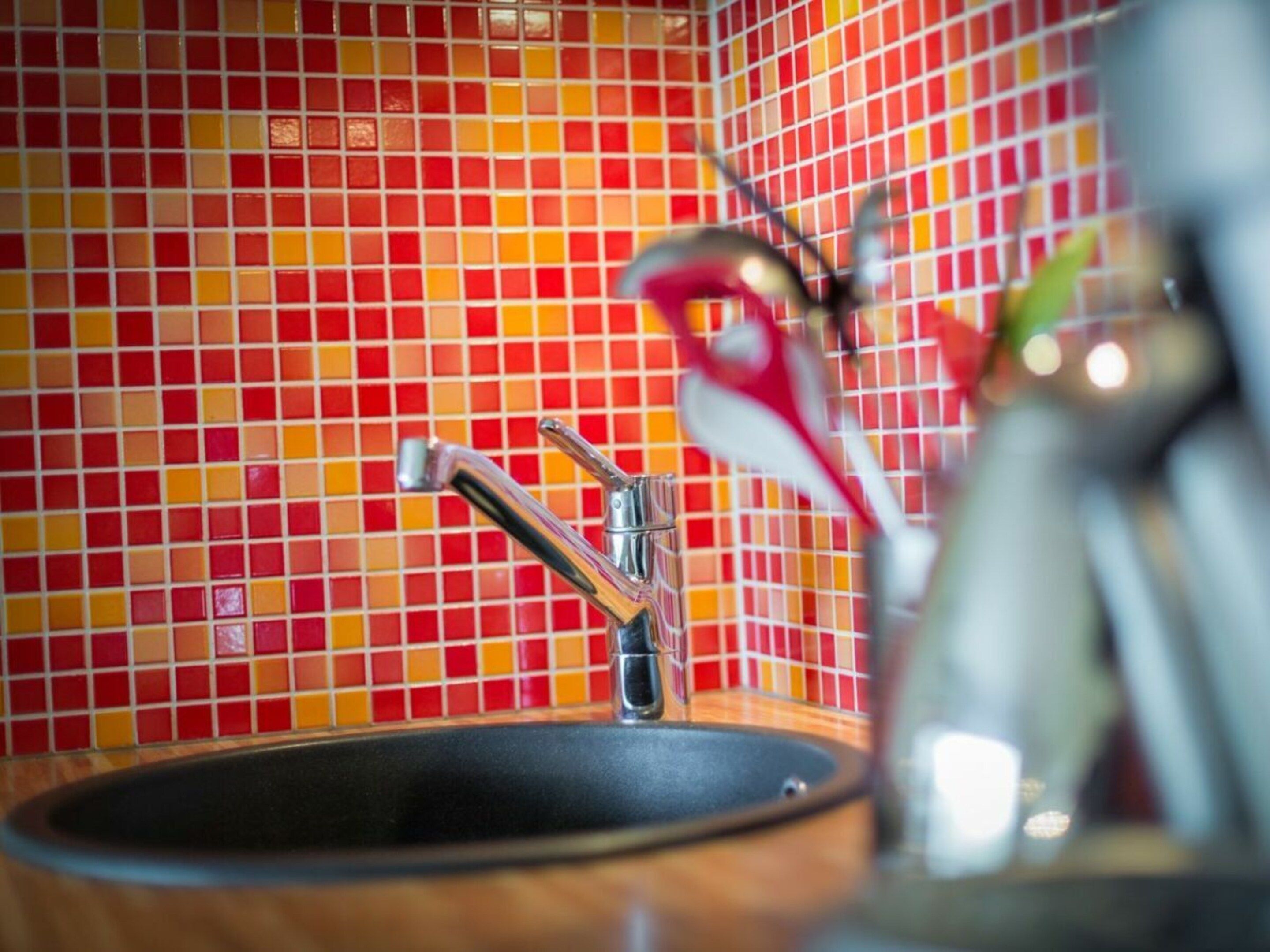 Een keuken met een betegelde achterwand en een spoelbak.