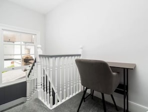 A room with a white railing, a grey chair, and a small table. - Stylish West London Home,Superking Bed, Workspace, Garden & Great Travel Connect (London)