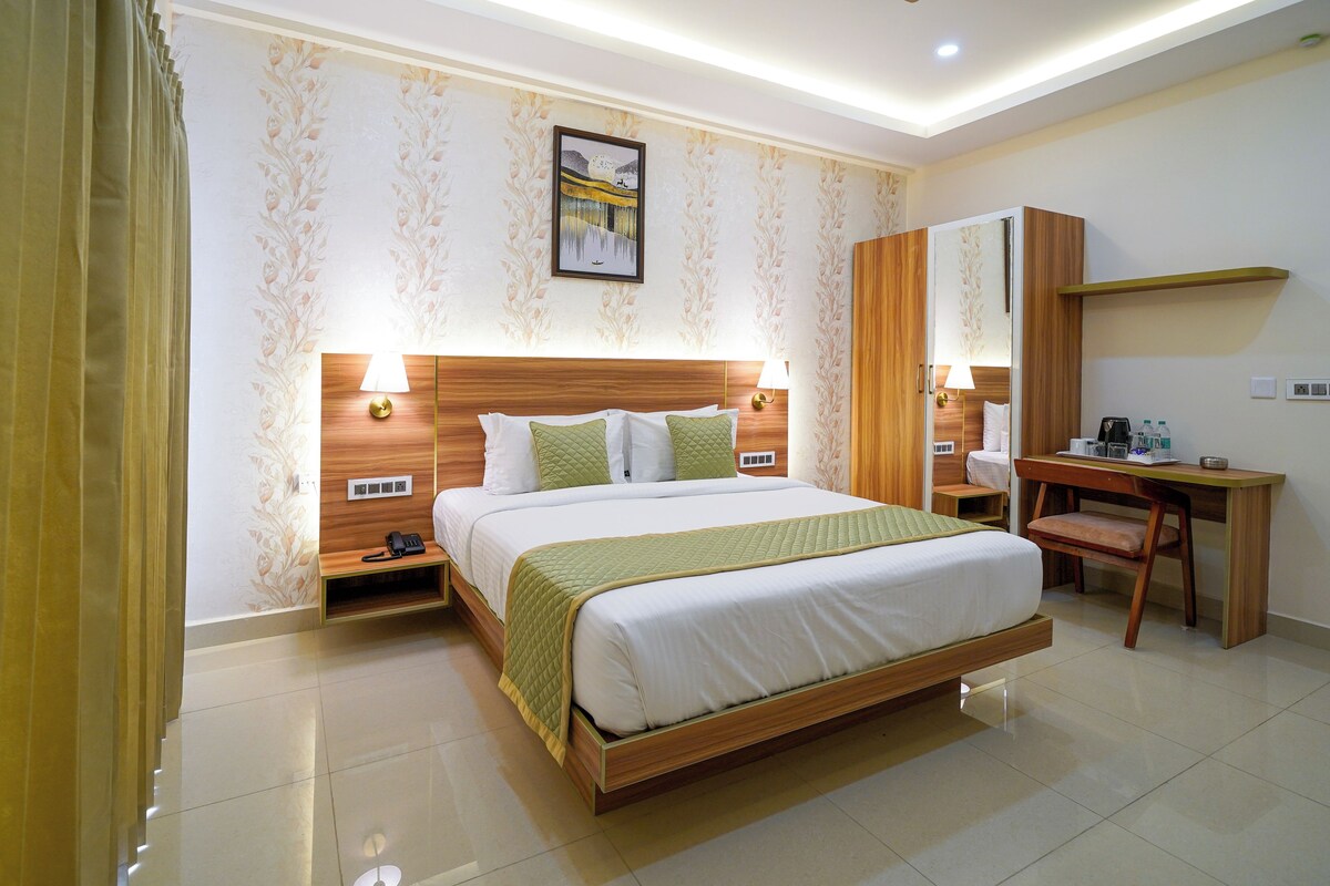 A hotel room with a large bed, bedside lamps, a desk, and a mirror.