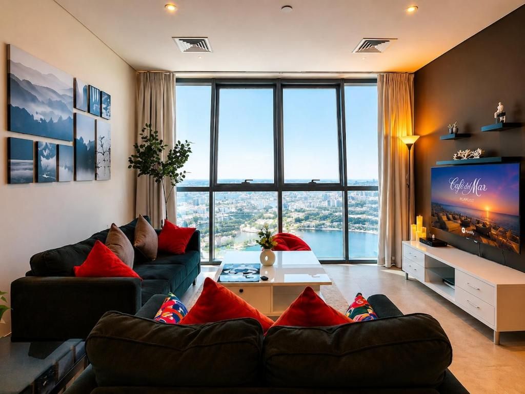 Un salon moderne avec une grande fenêtre, un canapé, une table basse et un téléviseur à écran plat.