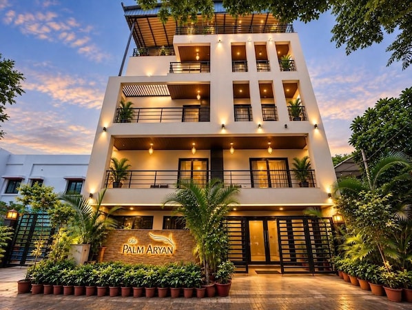 Un hotel de varios pisos con un letrero que dice 'The Palm Aryan'.
