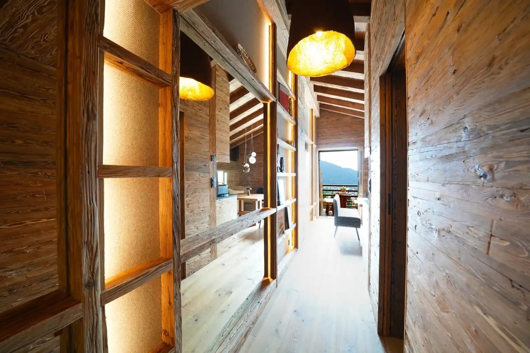 A wooden interior hallway with a view to the outside.