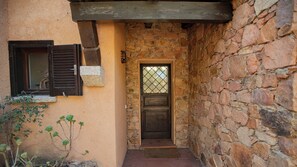 A narrow stone corridor with a wooden door and a window with shutters. - Kind & Secret:  villa with pool and panoramic rooftop terrace (Costa Paradiso)
