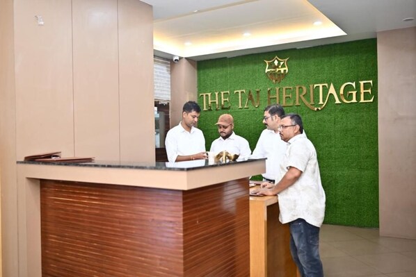 A reception desk with a green wall and a sign that reads 'The TN Heritage.'