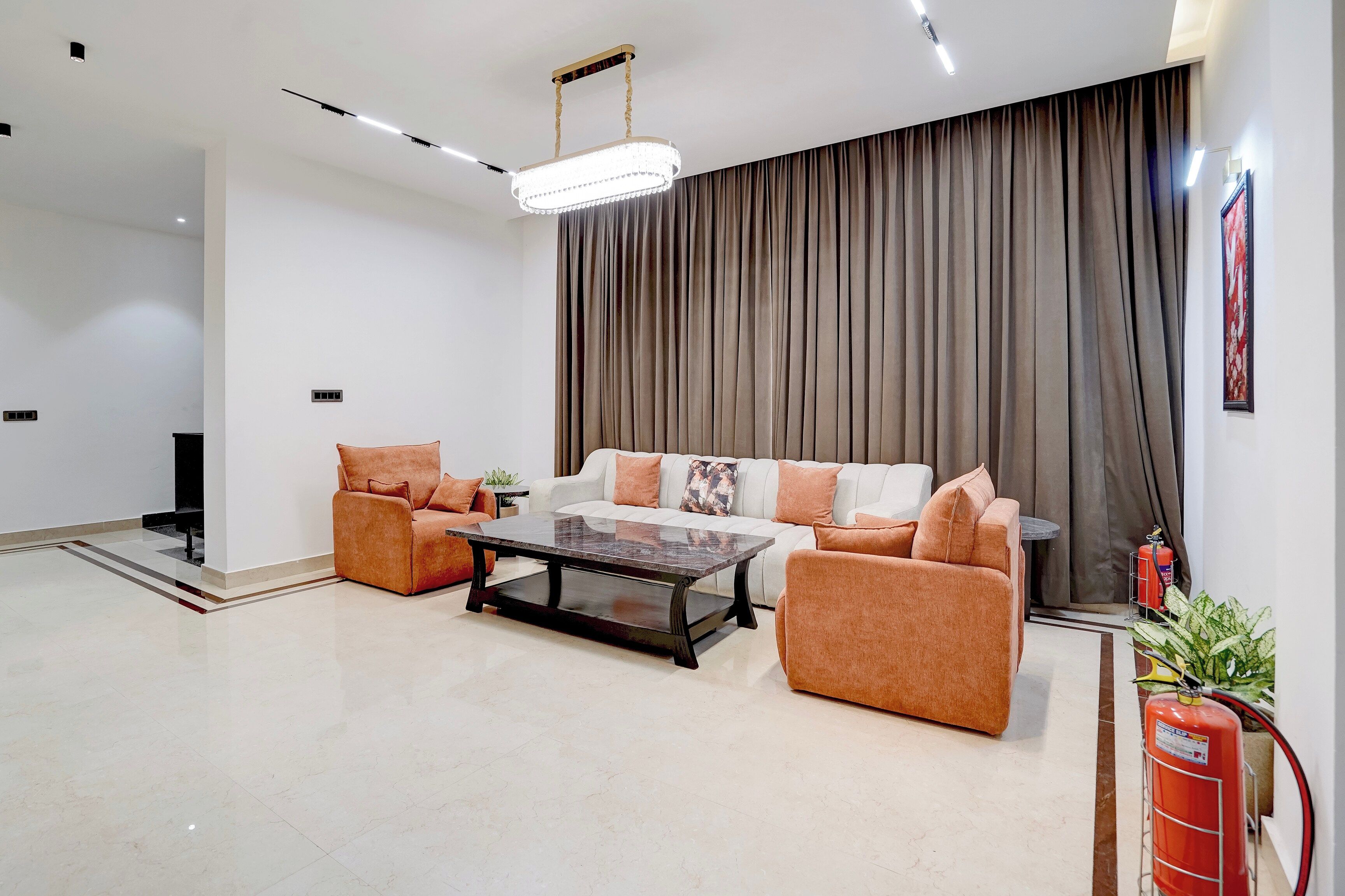 Una sala de estar moderna con un conjunto de sofá, una mesa de centro y un ventanal con cortinas.