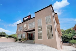 Un hotel con un letrero que dice 'OYO Sunshine Damtal' y una placa con el nombre 'SUNSHINE'.