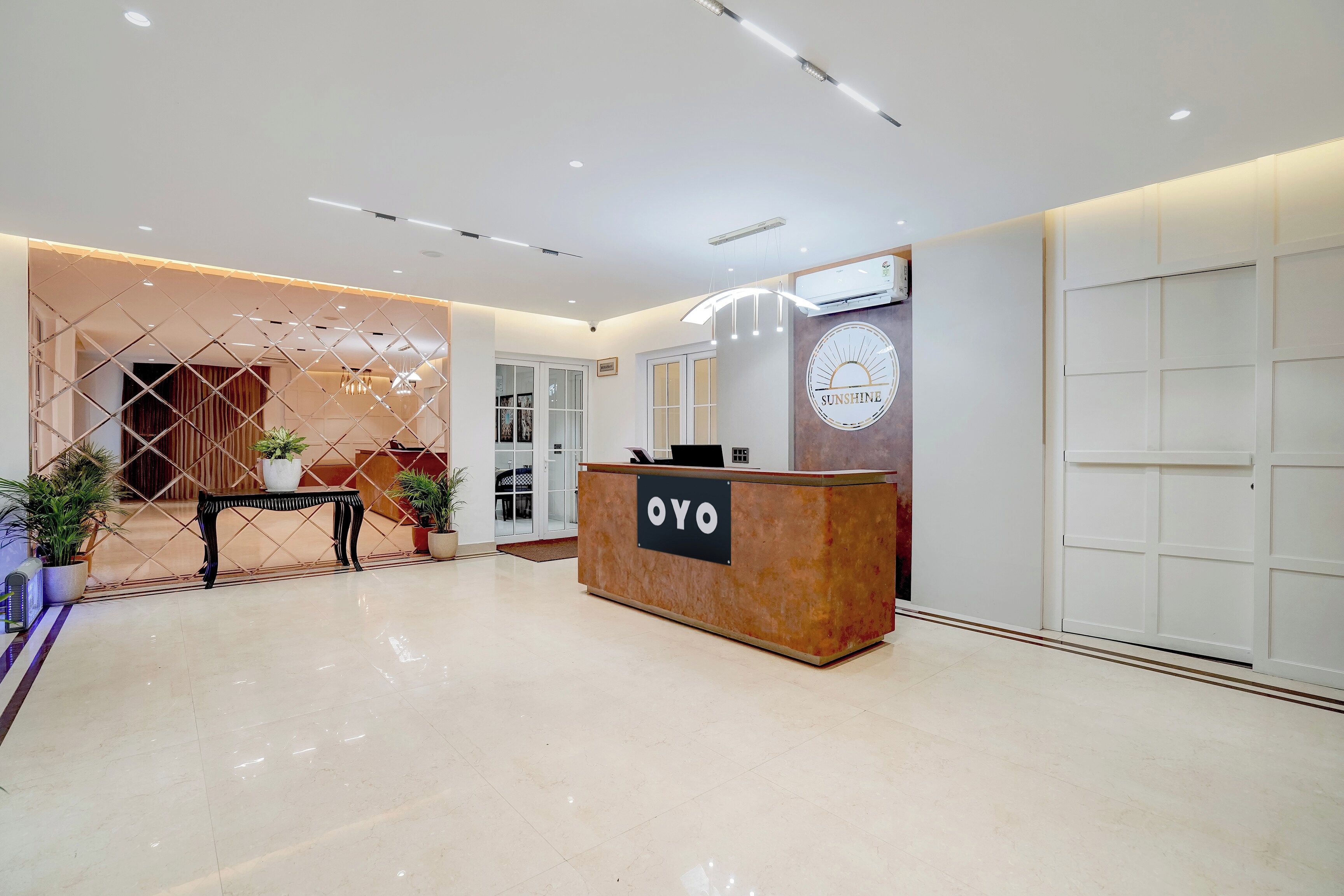 A reception area with a reception desk labeled 'OYO,' a wall clock, and a modern interior design.