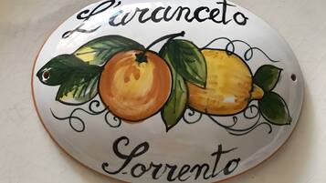 Une assiette en céramique ornée d’un motif de fruits et portant l’inscription « L’arcangelo Lorrento ».