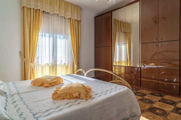 Ein Schlafzimmer mit Bett, Schrank und einem Badezimmerspiegel.