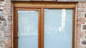 Un edificio de piedra con una puerta doble de madera que tiene paneles de vidrio esmerilado.