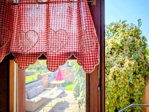 Ein Fenster mit einem roten und weißen Karomantel mit herzförmigen Ausschnitten.