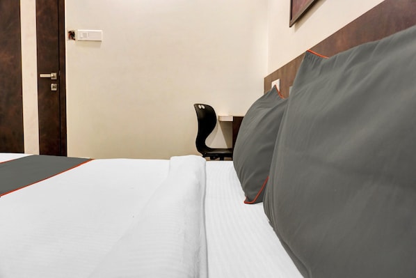 A hotel room with a bed, a desk, and a chair. - Collection O Royce Studios Near Pune (Pune)
