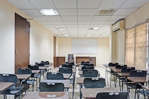 A classroom with rows of desks and chairs, a projector screen, and a whiteboard. - Collection O Royce Studios Near Pune (Pune)