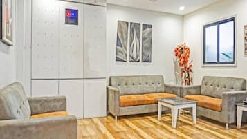 A modern living room with a grey sofa set, a coffee table, and a decorative plant.