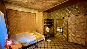 Une chambre avec un lit, un miroir, une armoire et une petite table.