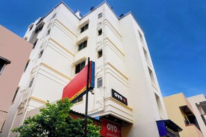 A multi-story building with a prominent red and blue sign indicating a business on the ground floor. - Hotel O Jaihind Building (Pune)