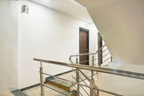 A staircase with metal railings leading to a door marked with the number 104. - Hotel O Jaihind Building (Pune)