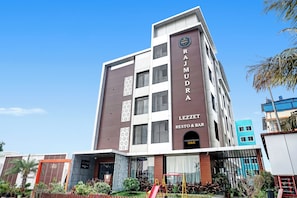 Un edificio de varios pisos con un cartel que dice 'RAJMUDRA LEZZET RESTO & BAR' en la fachada.